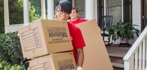 Two Marrin's Moving employees carrying cardboard boxes and smiling