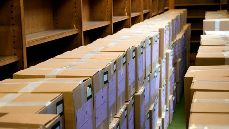 Line of cardboard boxes taped, labeled, and ready to be moved by Marrin's Moving