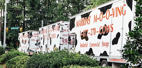 three marrins' moving trucks stopped at a stop light